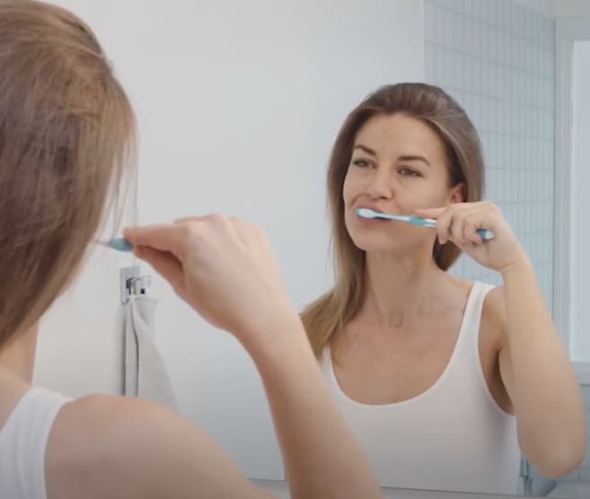 Young female technician looking into microscope in medical laboratory